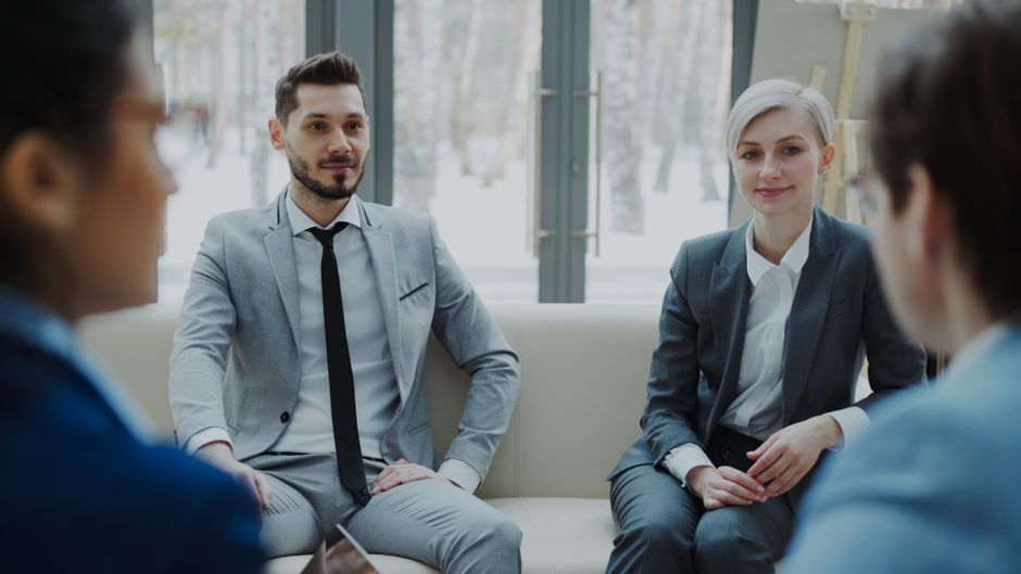 Business meeting with professionals in suits discussing in a modern office.